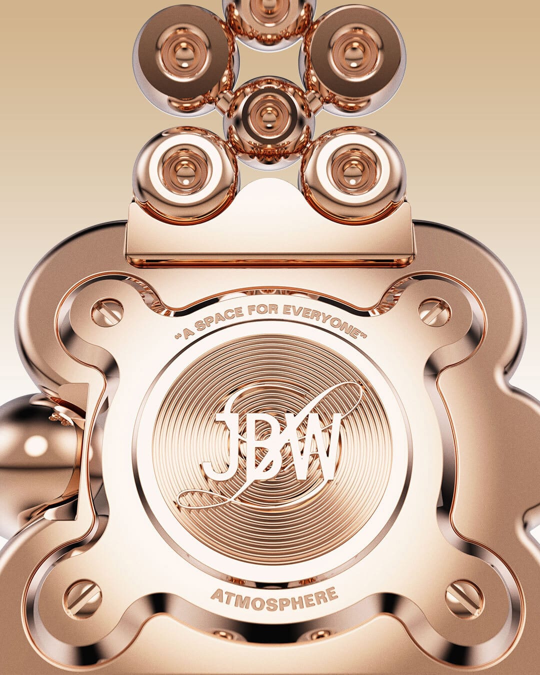Close-up of the JBW x Luar – Atmosphere | J6405D by JBW Watches: a shiny 18k rose gold-plated piece engraved with JBW at the center, circular decorative patterns, and the phrases A SPACE FOR EVERYONE and ATMOSPHERE.