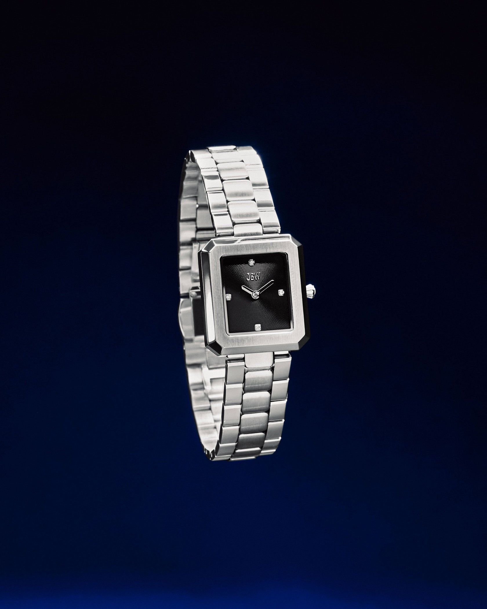 The JBW Watches Arc Single | J6390G is a gender-neutral silver wristwatch with a square black minimalist face, elegantly showcased on a dark blue gradient background.