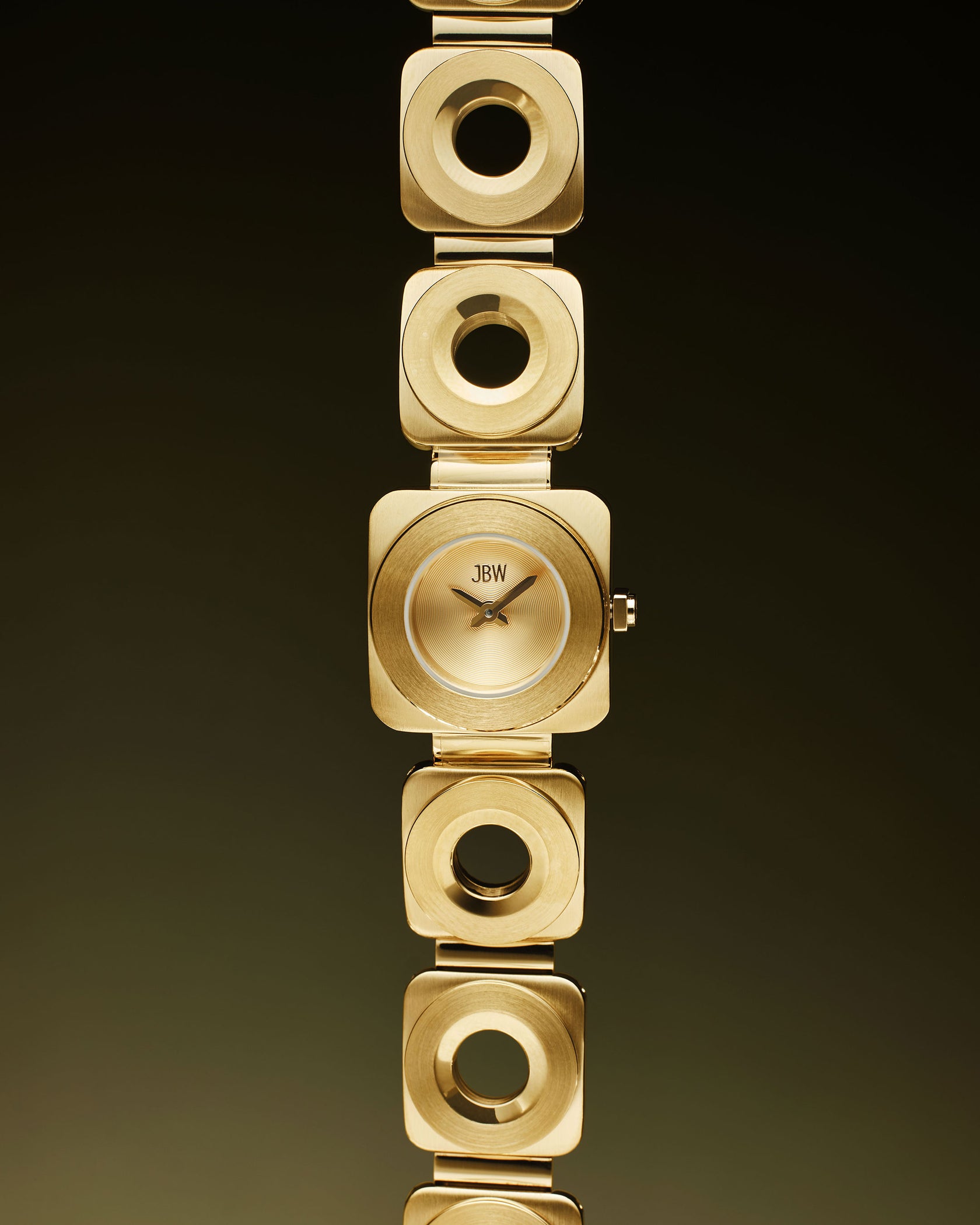 The Chasm | J6398A by JBW Watches features a square gold 18k gold-plated bracelet with square links and circular cutouts, shown vertically against a dark gradient background.