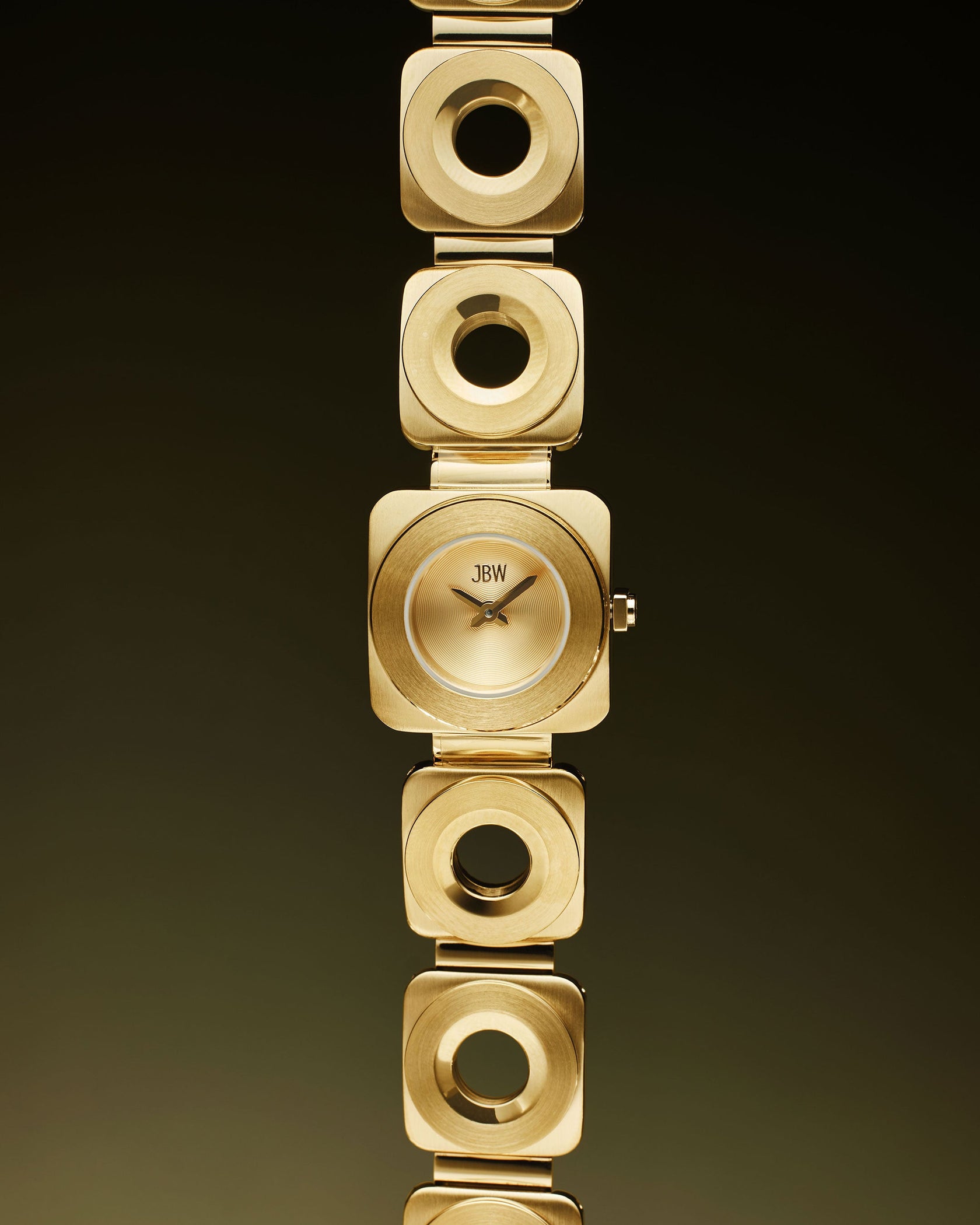 The Chasm | J6398A by JBW Watches features a square gold 18k gold-plated bracelet with square links and circular cutouts, shown vertically against a dark gradient background.