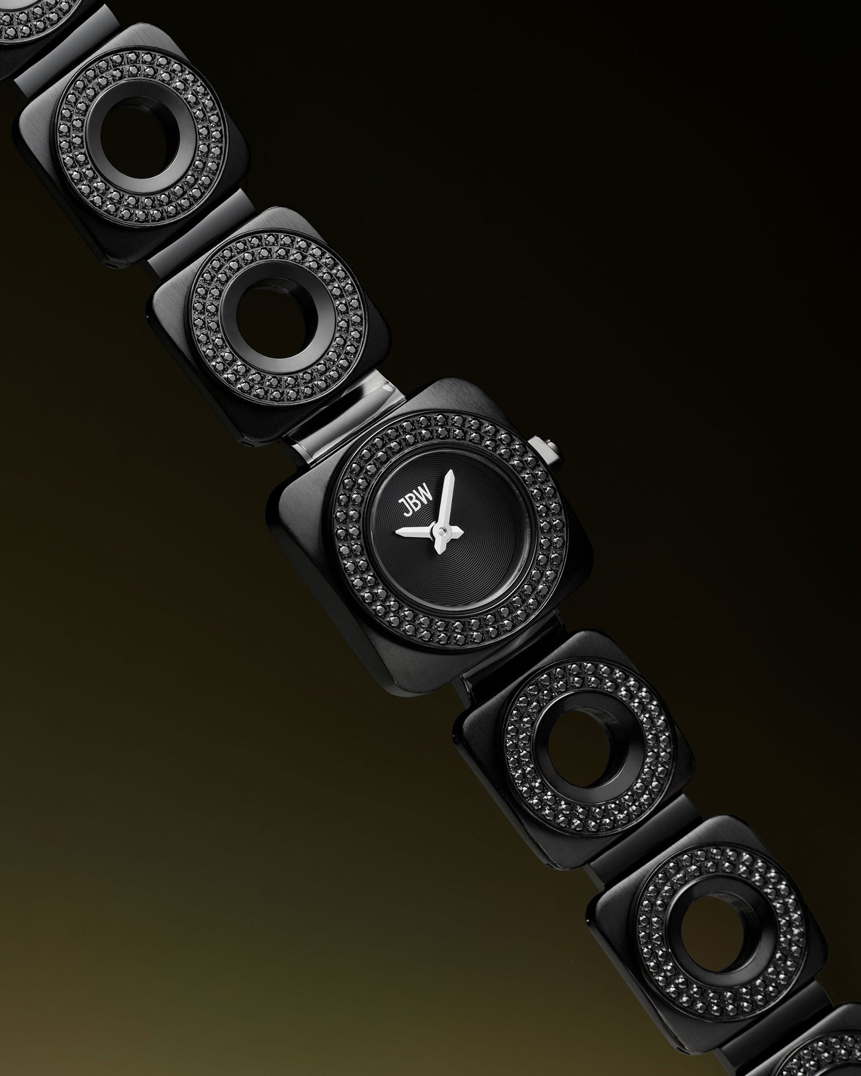 The JBW Watches Chasm | J6399C is a stylish black wristwatch featuring a square face and black circular links with premium crystals, elegantly displayed against a dark gradient background.