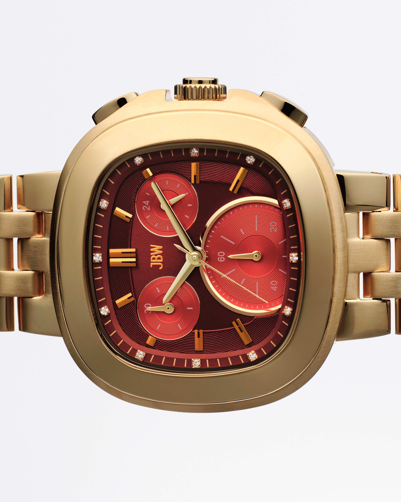 The JBW Watches Coast | J6397F is a gold wristwatch with a metallic band, square face with rounded edges, deep red dial, three Miyota-powered subdials, gold hour markers, and diamond accents around the bezel.