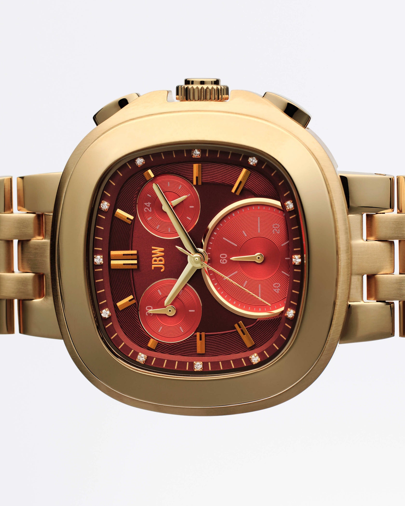 The JBW Watches Coast | J6397F is a gold wristwatch with a metallic band, square face with rounded edges, deep red dial, three Miyota-powered subdials, gold hour markers, and diamond accents around the bezel.