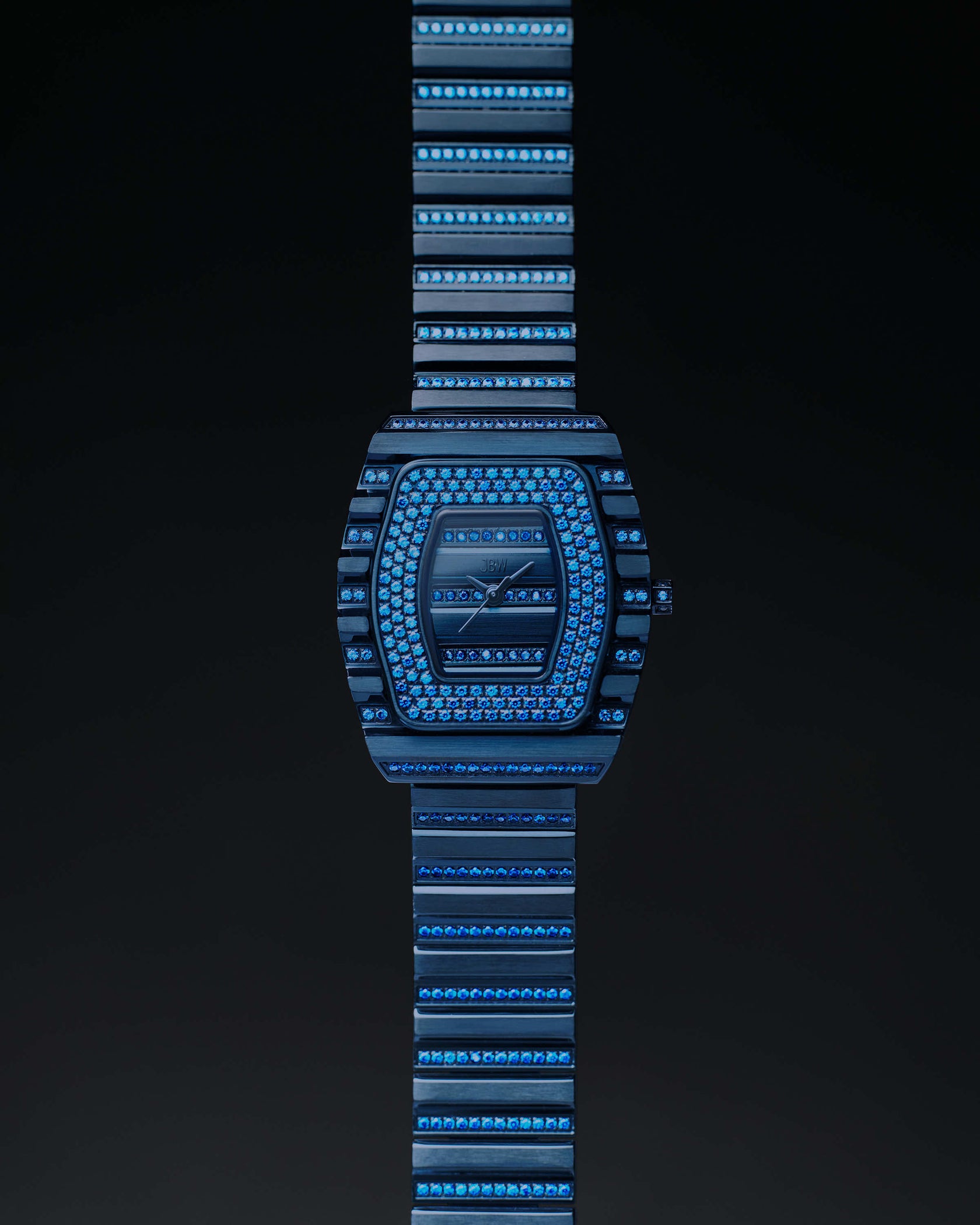 The RESERVE Atlas Bleu | R6404A by JBW Watches is a limited edition luxury blue crystal watch with gemstones, a geometric face, matching blue metal strap, Swiss quartz movement, shown on a dark background.