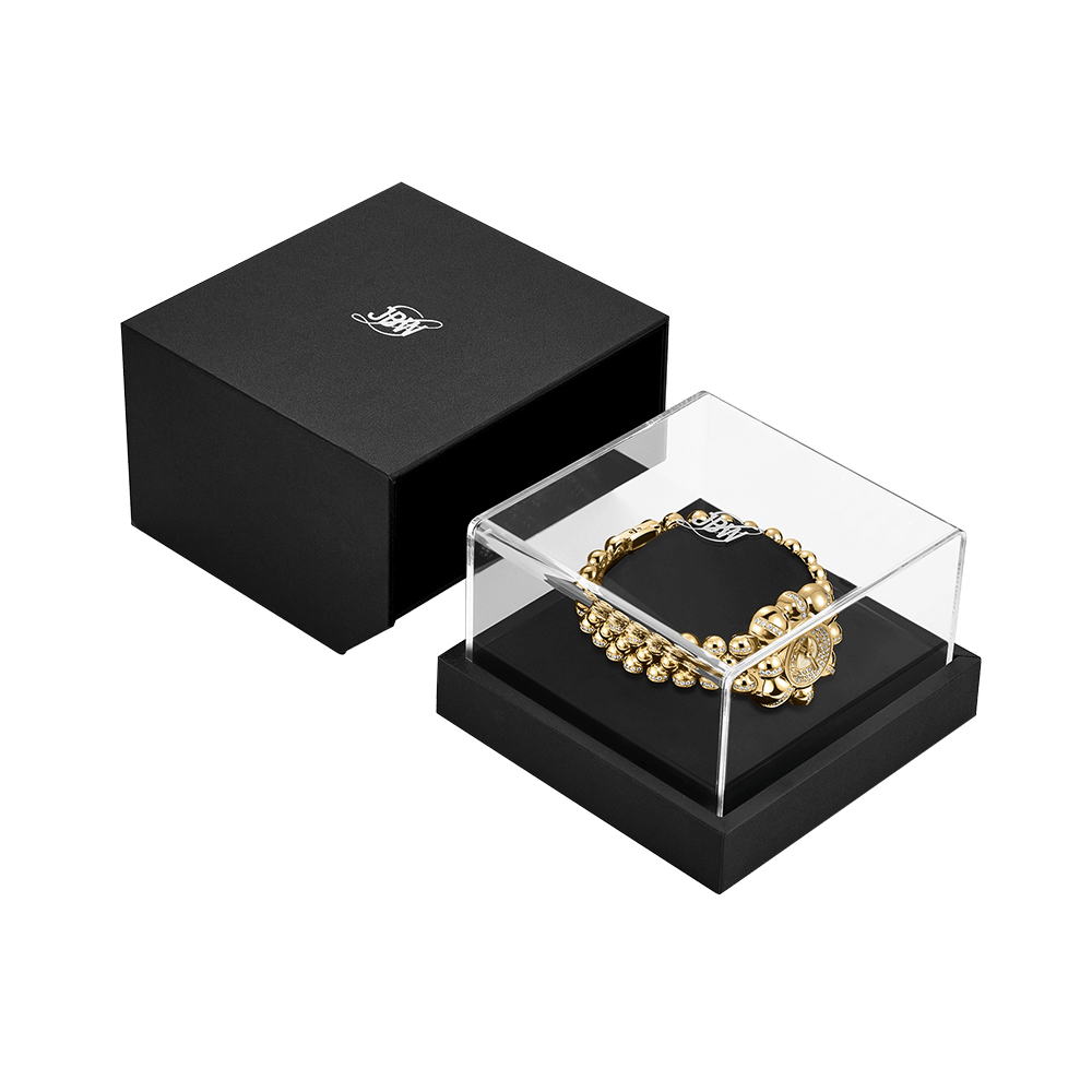 The JBW x Luar – Atmosphere (Sample Sale) | J6406A-SC by JBW Watches, a gold beaded bracelet in a clear acrylic case with black base and open logo jewelry box, exudes limited edition elegance atop a plain white background.