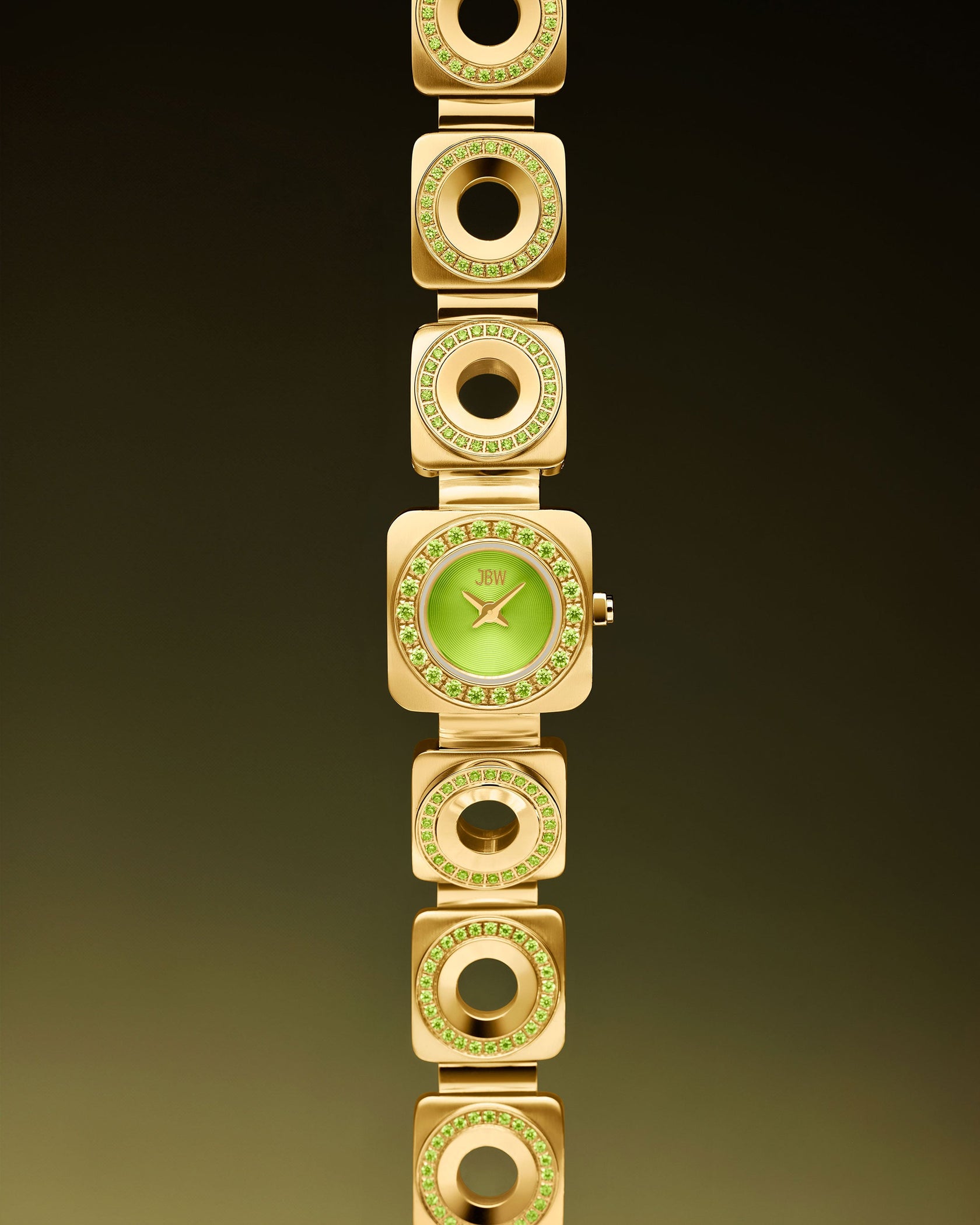 The JBW Watches Chasm Petite (Sample Sale) | J6401D-SC features a gold band with crystal-studded circular and square links, a square green face, and reliable Japanese VX movement, all set against a gradient dark background.