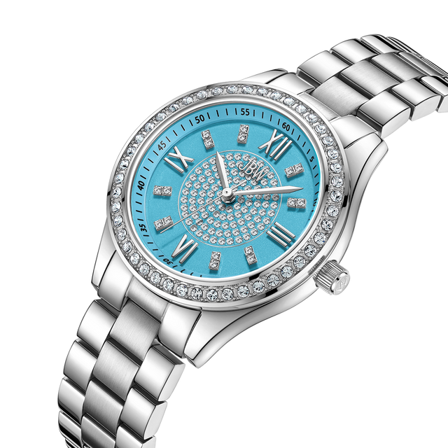 The Mondrian 34 | J6388E by JBW Watches features a jeweled bezel, bright blue face with Roman numerals and crystal hour markers, metal link band, and decorative crystals on the dial center. Swiss movement adds elegance to this silver wristwatch.
