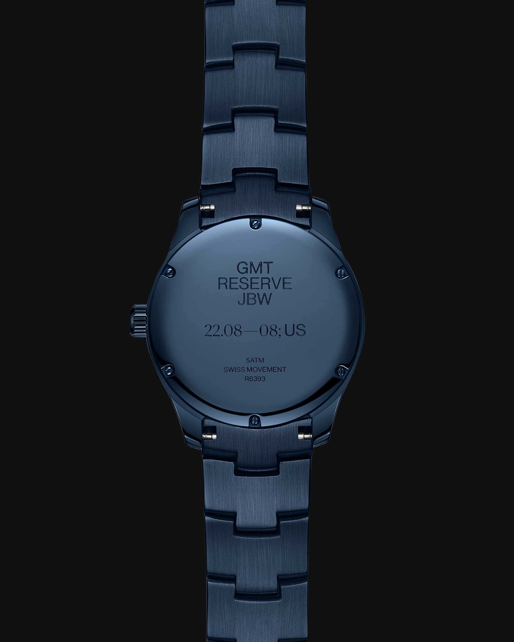 A RESERVE Bleu 39 | R6393A-GA by JBW Watches, shown from the back, displays engravings noting GMT RESERVE JBW, dates 22.08—08., US, 5 ATM water resistance, Swiss GMT movement, and code R232 on its sapphire blue crystal case.