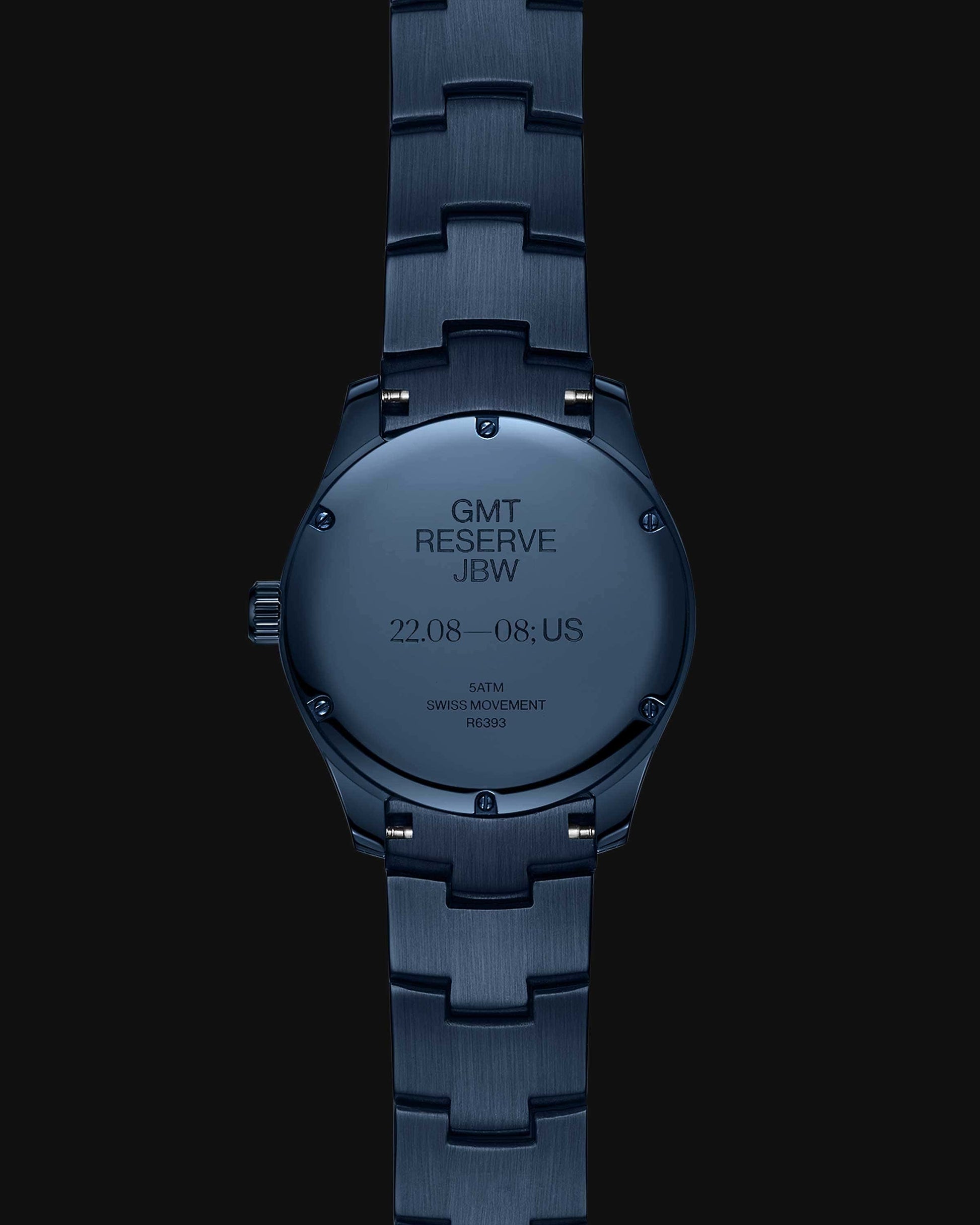 A RESERVE Bleu 39 | R6393A-GA by JBW Watches, shown from the back, displays engravings noting GMT RESERVE JBW, dates 22.08—08., US, 5 ATM water resistance, Swiss GMT movement, and code R232 on its sapphire blue crystal case.