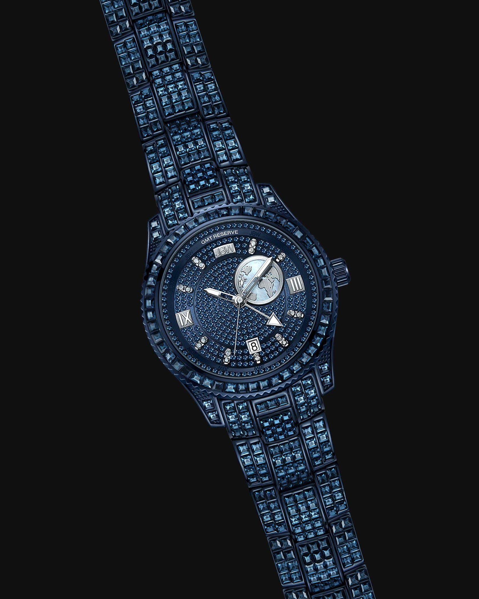 The RESERVE Bleu 39 | R6393A-GA by JBW Watches is a luxury sapphire blue crystals watch with gemstone accents on the band and face, Roman numerals, a date window, detailed round dial, and Swiss GMT movement—perfect for jet setters.