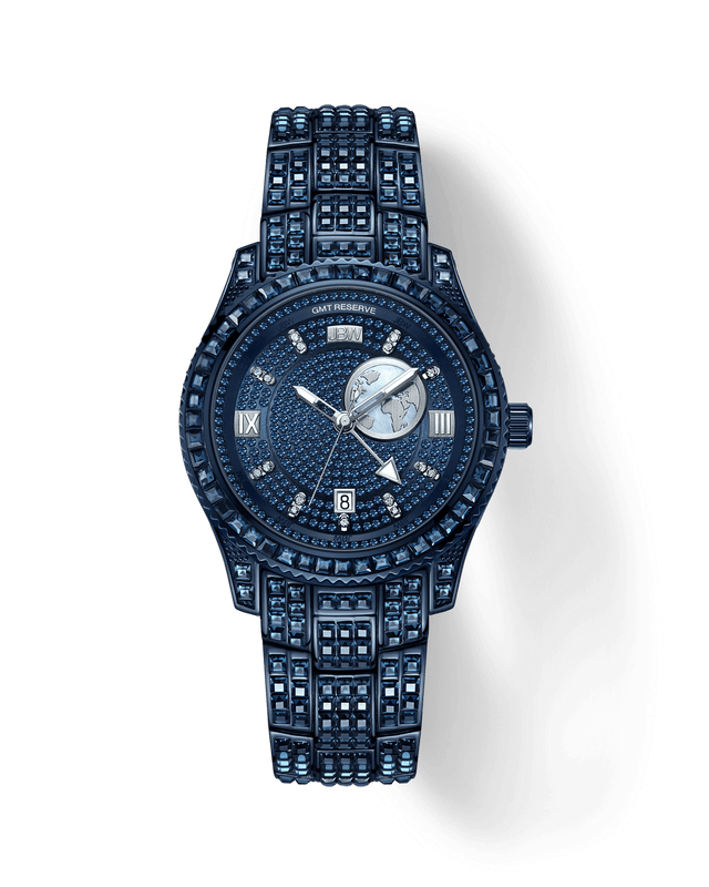 The RESERVE Bleu 39 | R6393A-GA by JBW Watches is a sapphire blue crystal watch with a round face, Roman numerals, sub-dial, and rectangular date window at 6 o’clock. Its band features blue stones for added elegance.